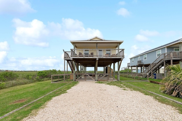 753 Bluewater Hwy, Surfside Beach, TX 77541 - view of front of house with stairway, driveway, and a front lawn