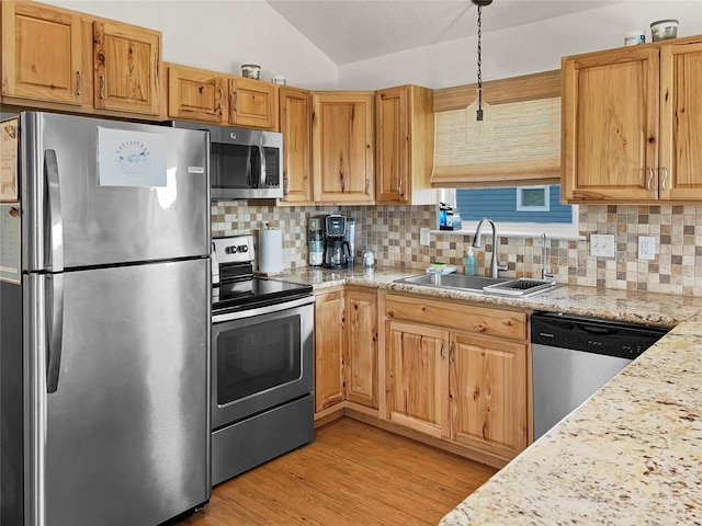 753 Bluewater Hwy, Surfside Beach, TX 77541 - kitchen with appliances with stainless steel finishes, a sink, decorative backsplash, vaulted ceiling, and light wood-style floors