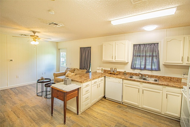 277 Lucy, Livingston, TX 77351 - kitchen with white dishwasher, a sink, a textured ceiling, a peninsula, and light wood-style floors