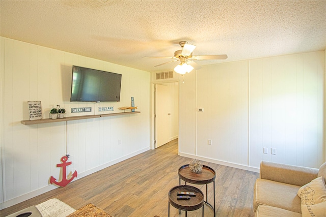277 Lucy, Livingston, TX 77351 - living room featuring wood finished floors, a ceiling fan, and a textured ceiling