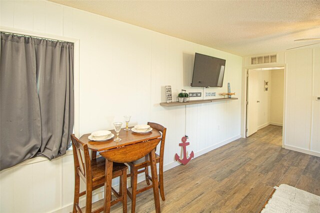 277 Lucy, Livingston, TX 77351 - dining space featuring wood finished floors, a textured ceiling, and a decorative wall