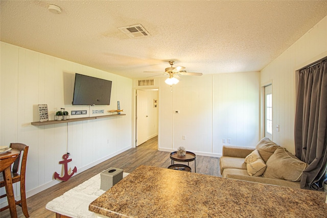 277 Lucy, Livingston, TX 77351 - living area featuring wood finished floors, a ceiling fan, a textured ceiling, and baseboards