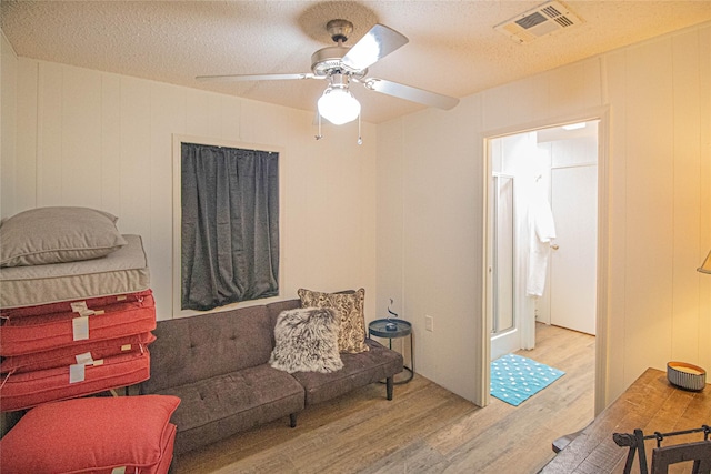 277 Lucy, Livingston, TX 77351 - living room with wood finished floors, ceiling fan, a decorative wall, and a textured ceiling