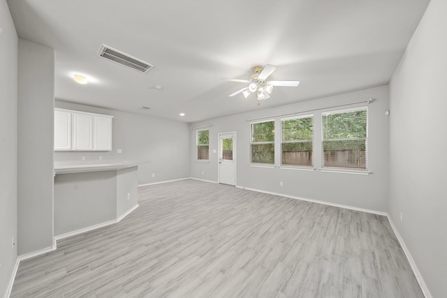 114 N Camellia Grove Cir, The Woodlands, TX 77382 - unfurnished living room with a ceiling fan, baseboards, and light wood-type flooring
