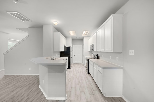 114 N Camellia Grove Cir, The Woodlands, TX 77382 - kitchen featuring appliances with stainless steel finishes, baseboards, light countertops, and a peninsula