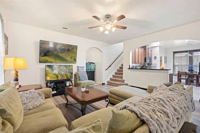 13610 Spectacled Bear Ln, Crosby, TX 77532 - living area with arched walkways, wood finished floors, stairway, and a ceiling fan