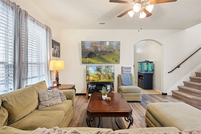 13610 Spectacled Bear Ln, Crosby, TX 77532 - living room with arched walkways, a ceiling fan, baseboards, and stairs