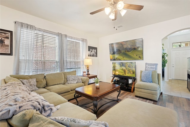 13610 Spectacled Bear Ln, Crosby, TX 77532 - living area featuring arched walkways, ceiling fan, plenty of natural light, and wood finished floors