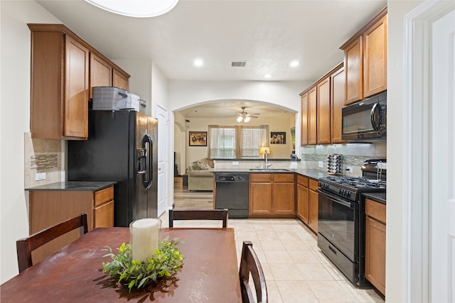 13610 Spectacled Bear Ln, Crosby, TX 77532 - kitchen featuring black appliances, dark countertops, arched walkways, backsplash, and recessed lighting