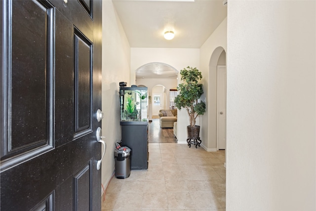 13610 Spectacled Bear Ln, Crosby, TX 77532 - entryway featuring arched walkways, light tile patterned floors, and baseboards