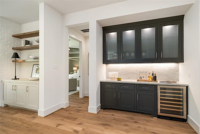 1611 Richelieu Ln, Houston, TX 77018 - indoor wet bar with beverage cooler, light wood-style floors, and tasteful backsplash