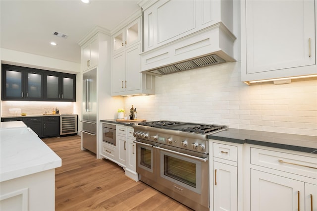 1611 Richelieu Ln, Houston, TX 77018 - kitchen featuring high quality appliances, wine cooler, recessed lighting, backsplash, and light wood finished floors