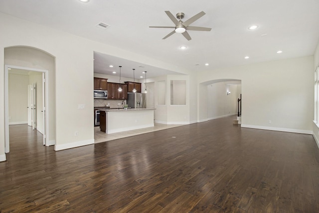 19903 Mulberry Pine Ln, Cypress, TX 77429 - unfurnished living room with arched walkways, ceiling fan, wood finished floors, recessed lighting, and baseboards