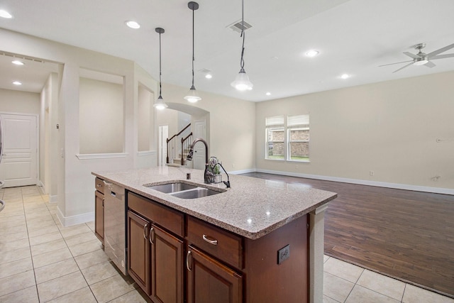 19903 Mulberry Pine Ln, Cypress, TX 77429 - kitchen with a sink, light tile patterned floors, stainless steel dishwasher, a ceiling fan, and arched walkways