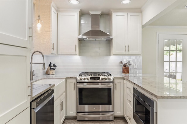 1709 Chantilly Ln, Houston, TX 77018 - kitchen with stainless steel appliances, wall chimney exhaust hood, a peninsula, white cabinets, and ornamental molding