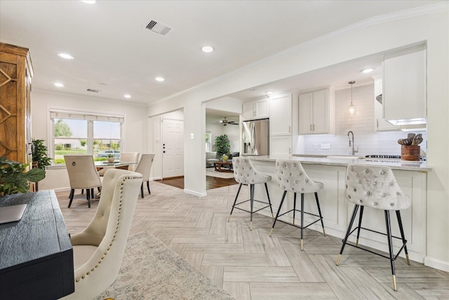 1709 Chantilly Ln, Houston, TX 77018 - kitchen featuring stainless steel fridge, baseboards, white cabinets, crown molding, and a peninsula