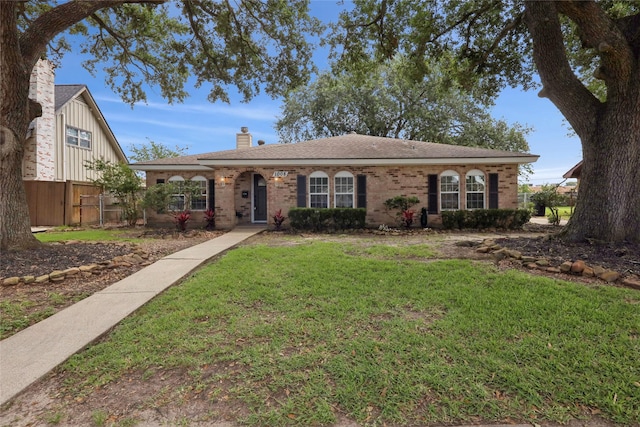 1008 N 30th St, Nederland, TX 77627 - view of front facade featuring a chimney, brick siding, and roof with shingles