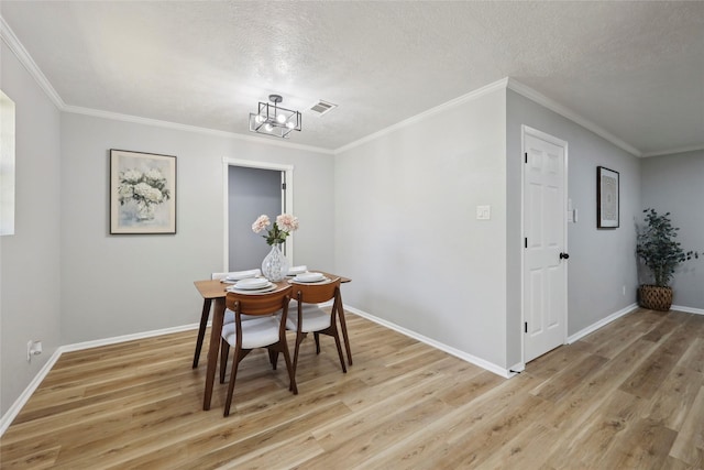 1008 N 30th St, Nederland, TX 77627 - dining area with light wood-type flooring, ornamental molding, a textured ceiling, baseboards, and a chandelier