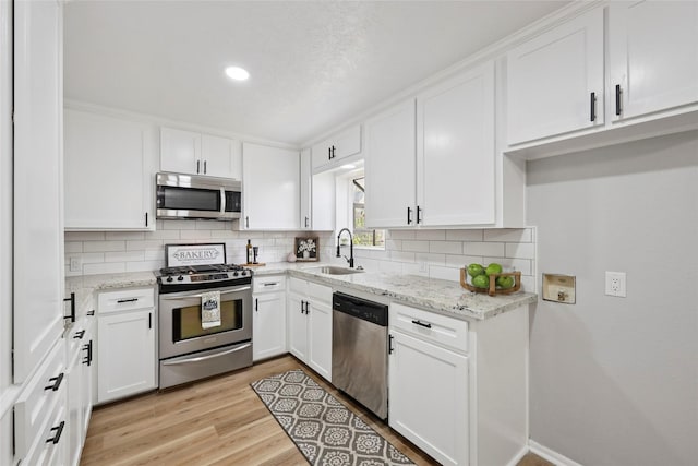 1008 N 30th St, Nederland, TX 77627 - kitchen with stainless steel appliances, a sink, tasteful backsplash, white cabinets, and recessed lighting