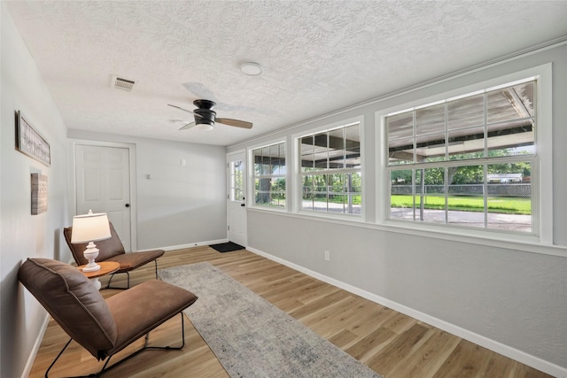 1008 N 30th St, Nederland, TX 77627 - sitting room featuring a textured ceiling, a ceiling fan, wood finished floors, and baseboards
