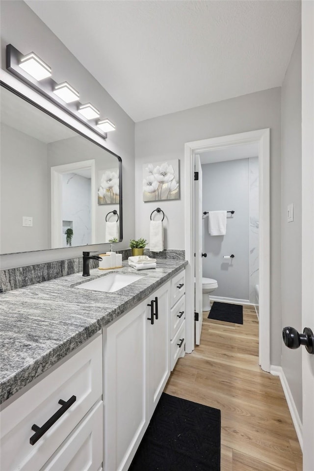 1008 N 30th St, Nederland, TX 77627 - bathroom with vanity, toilet, wood finished floors, and baseboards