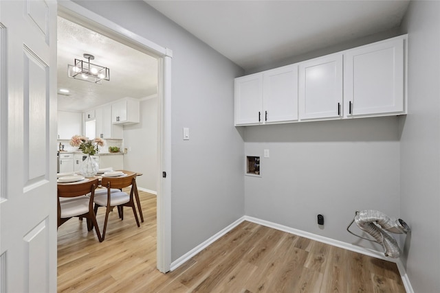 1008 N 30th St, Nederland, TX 77627 - washroom featuring cabinet space, washer hookup, light wood-style flooring, and baseboards