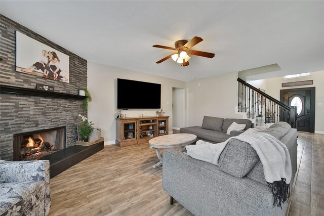 15314 Yellow Oak Trl, Cypress, TX 77433 - living room with a ceiling fan, stairs, a stone fireplace, and wood finished floors