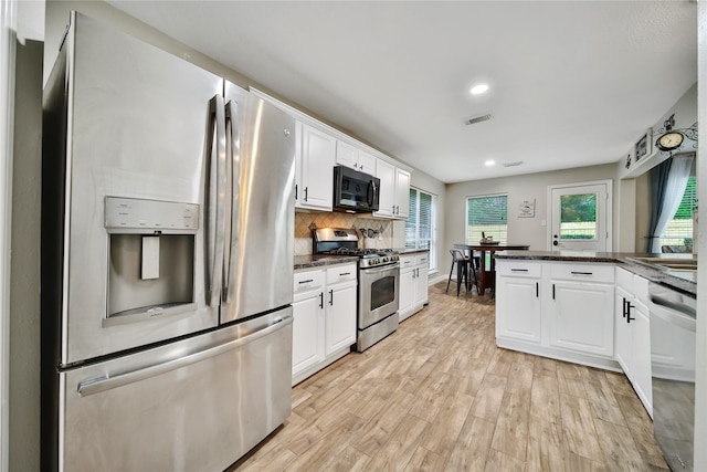 15314 Yellow Oak Trl, Cypress, TX 77433 - kitchen with appliances with stainless steel finishes, light wood finished floors, white cabinetry, tasteful backsplash, and recessed lighting