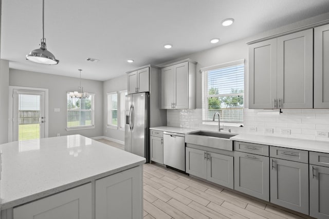 2302 Elmwood Trl, Katy, TX 77493 - kitchen featuring appliances with stainless steel finishes, a sink, gray cabinetry, plenty of natural light, and recessed lighting
