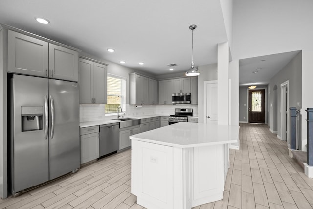 2302 Elmwood Trl, Katy, TX 77493 - kitchen with stainless steel appliances, gray cabinetry, a sink, light countertops, and backsplash