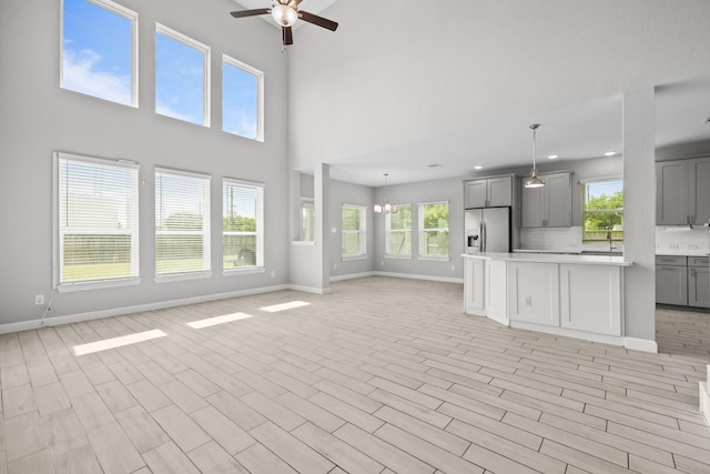 2302 Elmwood Trl, Katy, TX 77493 - kitchen with stainless steel fridge, gray cabinets, open floor plan, light countertops, and a ceiling fan