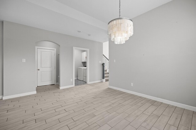 2302 Elmwood Trl, Katy, TX 77493 - spare room with washer / clothes dryer, baseboards, a chandelier, and arched walkways