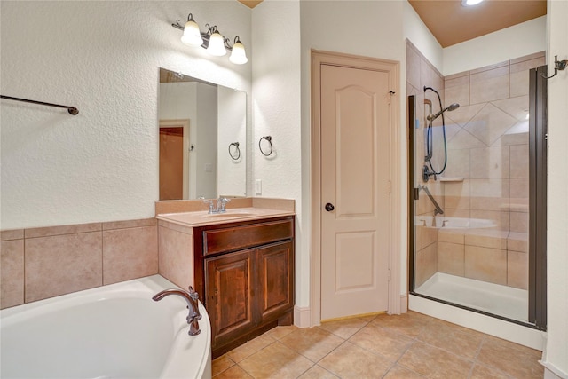 10 Tallgrass Way, Spring, TX 77389 - bathroom featuring a shower stall, a garden tub, a textured wall, vanity, and tile patterned flooring