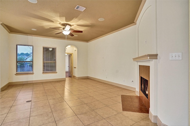 10 Tallgrass Way, Spring, TX 77389 - unfurnished living room with ornamental molding, ceiling fan, light tile patterned floors, a textured ceiling, and a fireplace