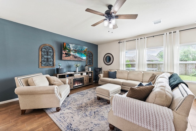 14706 Meadow Acre Trl, Houston, TX 77049 - living area with ceiling fan, wood finished floors, a lit fireplace, and baseboards
