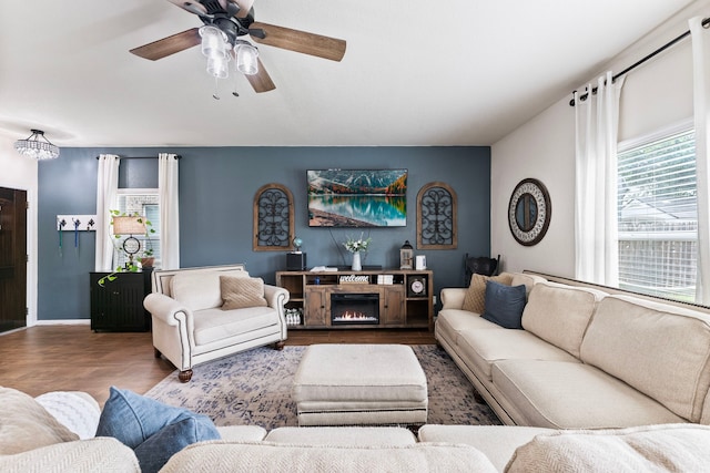 14706 Meadow Acre Trl, Houston, TX 77049 - living area with a ceiling fan, wood finished floors, a lit fireplace, and baseboards