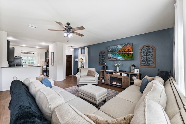 14706 Meadow Acre Trl, Houston, TX 77049 - living room with a ceiling fan, wood finished floors, baseboards, and a lit fireplace
