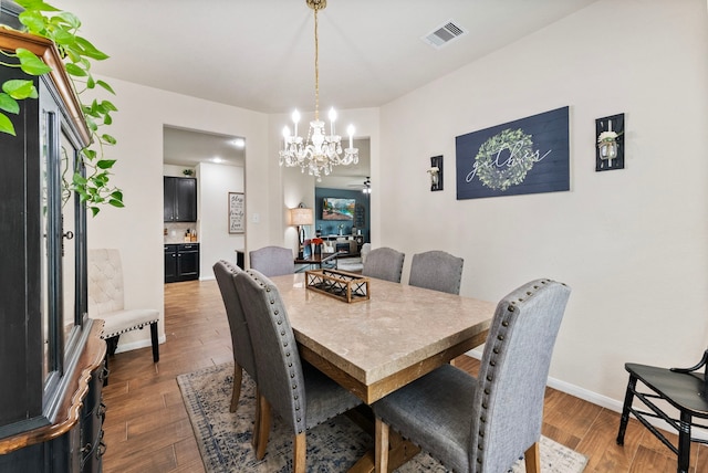 14706 Meadow Acre Trl, Houston, TX 77049 - dining room featuring dark wood-style floors, a chandelier, and baseboards