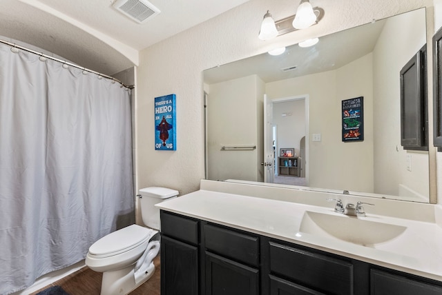14706 Meadow Acre Trl, Houston, TX 77049 - full bath with toilet, vanity, wood finished floors, a shower with shower curtain, and a textured wall