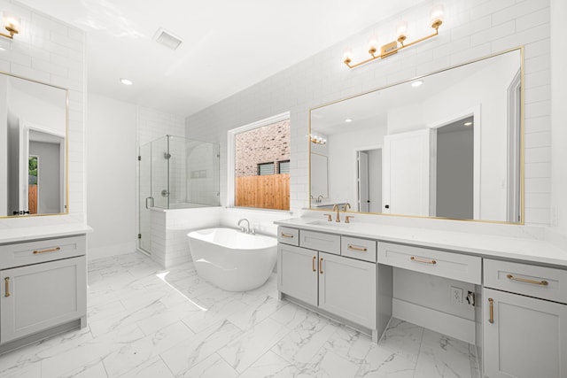 7913 Turquoise Ln, Houston, TX 77055 - bathroom featuring a shower stall, vanity, a freestanding tub, marble look tile flooring, and recessed lighting