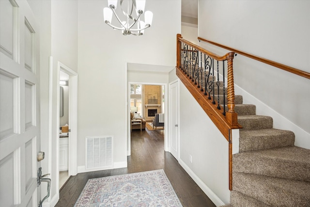 706 St Ives Ct, Houston, TX 77079 - entryway featuring a chandelier, a high ceiling, stairway, dark wood-type flooring, and baseboards