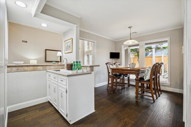 706 St Ives Ct, Houston, TX 77079 - kitchen with a peninsula, white cabinets, dark wood-type flooring, a sink, and crown molding