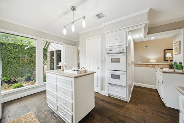 706 St Ives Ct, Houston, TX 77079 - kitchen with white double oven, white cabinetry, crown molding, an island with sink, and dark wood-style floors