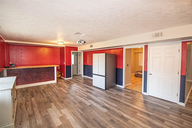 374 Harbor View Dr, Livingston, TX 77351 - unfurnished living room with dark wood-type flooring, a textured ceiling, and baseboards