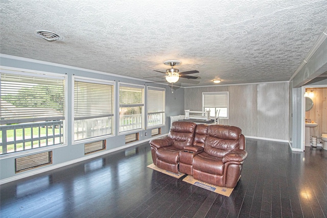 374 Harbor View Dr, Livingston, TX 77351 - living room featuring baseboards, a ceiling fan, ornamental molding, wood finished floors, and a textured ceiling