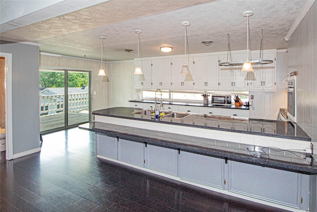 374 Harbor View Dr, Livingston, TX 77351 - kitchen featuring dark countertops, appliances with stainless steel finishes, a textured ceiling, white cabinets, and decorative light fixtures