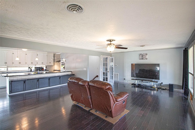 374 Harbor View Dr, Livingston, TX 77351 - living room with dark wood-type flooring, a textured ceiling, a ceiling fan, and ornamental molding