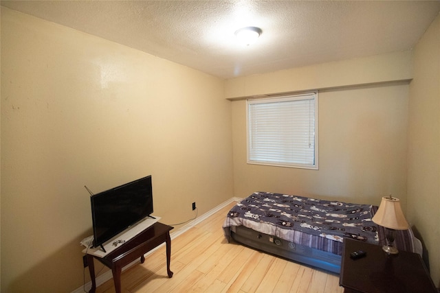 374 Harbor View Dr, Livingston, TX 77351 - bedroom with wood finished floors, baseboards, and a textured ceiling