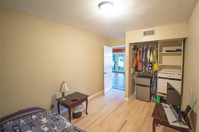 374 Harbor View Dr, Livingston, TX 77351 - bedroom with light wood finished floors, a textured ceiling, baseboards, and a closet
