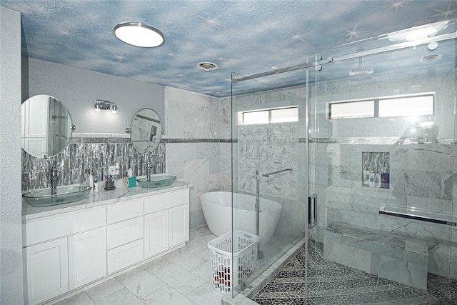 374 Harbor View Dr, Livingston, TX 77351 - full bathroom featuring tile walls, double vanity, a shower stall, marble finish flooring, and a soaking tub